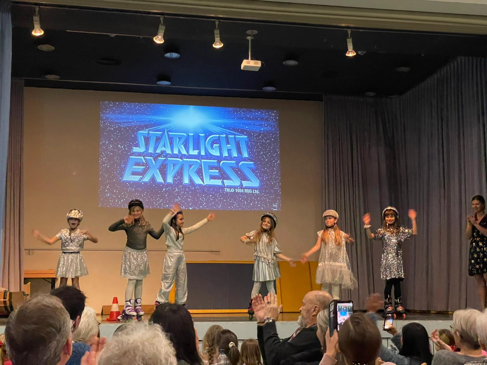 Kinder führen bei Weihnachtfeier auf Rollschuhen Starlight Express auf